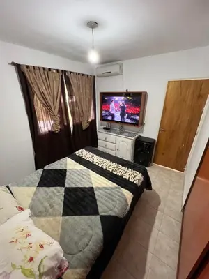 a bedroom with a bed and a flat screen tv at La Armonía in Potrero de Garay