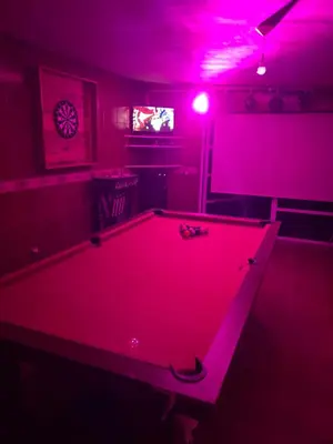 a pool table in a room with pink lights at La Armonía in Potrero de Garay