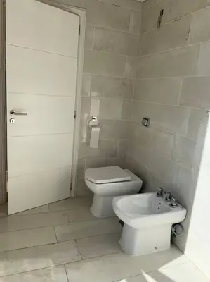 a white bathroom with a toilet and a bidet at Casa Cabalango in Cavalango