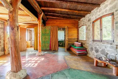 a living room with wooden ceilings and a stone wall at Habitaciones individuales en La Llave in San Javier