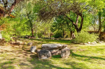 a stone bench in a park with trees and grass at Habitaciones individuales en La Llave in San Javier