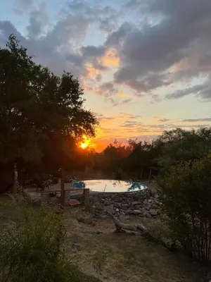 a hot tub in a field with the sunset in the background at Habitaciones individuales en La Llave in San Javier
