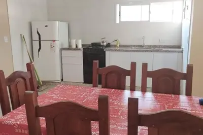 a kitchen with a table and chairs and a refrigerator at Cabañas Los Ranqueles in Merlo