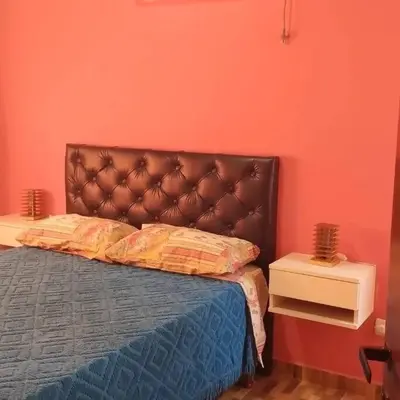 a bed with a brown headboard in a room at Cabañas Los Ranqueles in Merlo