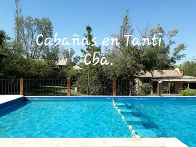 a swimming pool with blue water in a yard at CABAÑA Aguadita Tanti in Tanti