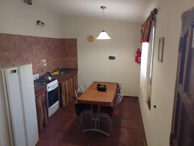 a small kitchen with a wooden table and a stove at CABAÑA Aguadita Tanti in Tanti