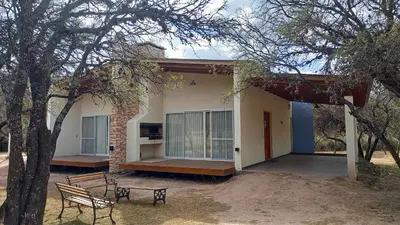 a house with two benches in front of it at El Principio Palace in Villa Cura Brochero