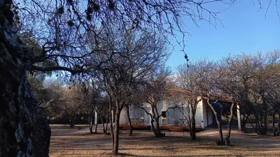 a house with a group of trees in front of it at El Principio Palace in Villa Cura Brochero