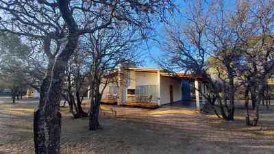 a small house in the middle of some trees at El Principio Palace in Villa Cura Brochero
