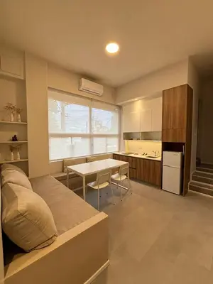 a bedroom with a bed and a kitchen with a table at Nori Boutique Apartment in Villa Carlos Paz