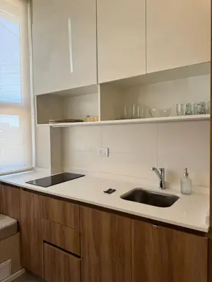 a kitchen with a sink and white cabinets at Nori Boutique Apartment in Villa Carlos Paz