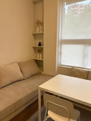 a living room with a couch and a table and a window at Nori Boutique Apartment in Villa Carlos Paz