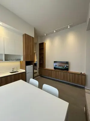 a kitchen with a table and a tv on a wall at Nori Boutique Apartment in Villa Carlos Paz