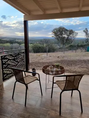 a patio with two chairs and a table with a view at Chalet REMANSO DE PAZ in Los Reartes