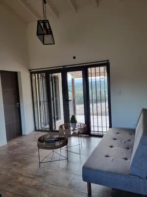 a living room with a couch and tables and windows at Chalet REMANSO DE PAZ in Los Reartes
