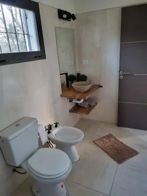 a bathroom with a toilet and a sink and a mirror at Chalet REMANSO DE PAZ in Los Reartes