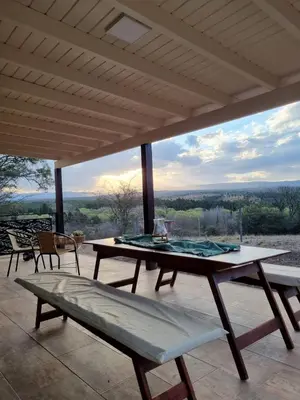 a table and chairs on a patio with a view at Chalet REMANSO DE PAZ in Los Reartes