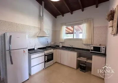 a kitchen with white appliances and a white refrigerator at FINCA FRANCK - Hospedaje de Montaña in Los Reartes
