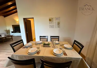 a dining room table with chairs and a white table cloth at FINCA FRANCK - Hospedaje de Montaña in Los Reartes