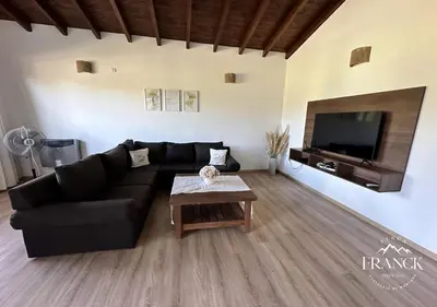 a living room with a black couch and a table at FINCA FRANCK - Hospedaje de Montaña in Los Reartes