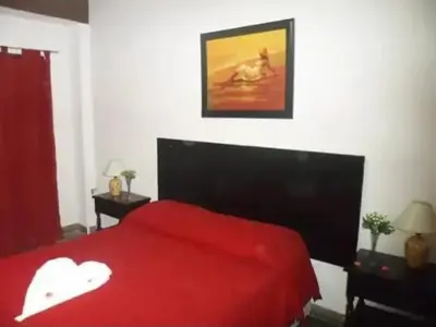 a bedroom with a red bed with a red blanket at Complejo Luluara in Villa Carlos Paz