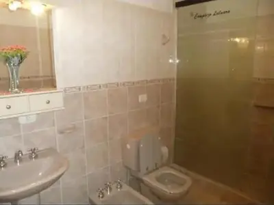 a bathroom with a toilet and a sink at Complejo Luluara in Villa Carlos Paz