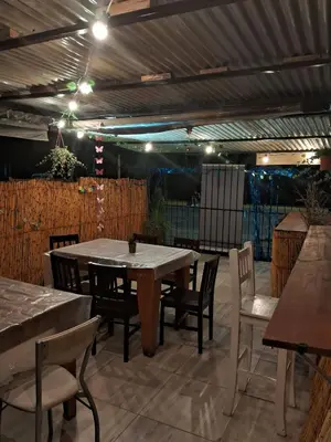 a patio with a table and chairs and lights at Complejo Luluara in Villa Carlos Paz