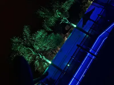 a blue building with a christmas tree in front of it at Complejo Luluara in Villa Carlos Paz
