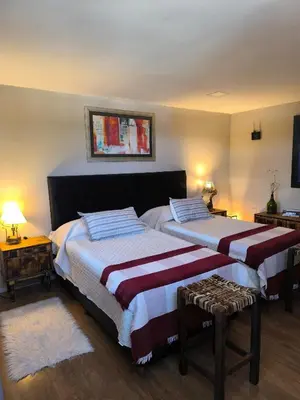 a bedroom with two beds and a table at Complejo Varge Norte in Alta Gracia