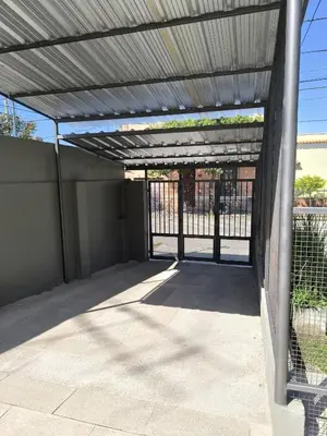 an open garage with a metal roof at Complejo Varge Norte in Alta Gracia