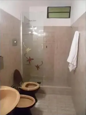 a bathroom with a toilet and a sink and a shower at Complejo Luluara in Villa Carlos Paz