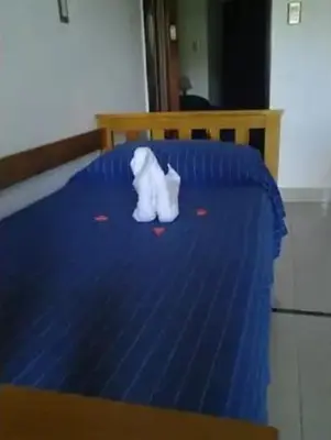 a teddy bear sitting on top of a blue bed at Complejo Luluara in Villa Carlos Paz