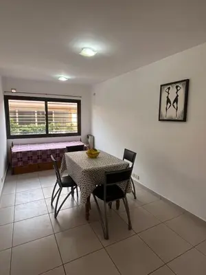 a dining room with a table and chairs and a window at Departamentos Económicos Medrano in Villa Carlos Paz