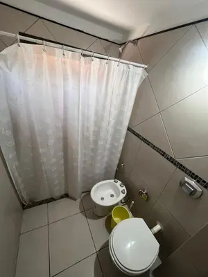 a small bathroom with a toilet and a shower curtain at Departamentos Económicos Medrano in Villa Carlos Paz