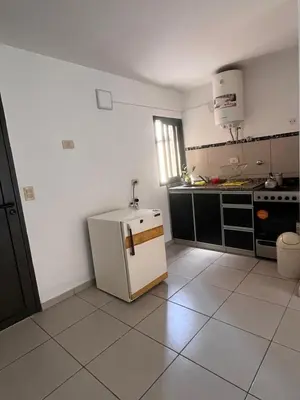a kitchen with a small white refrigerator in it at Departamentos Económicos Medrano in Villa Carlos Paz