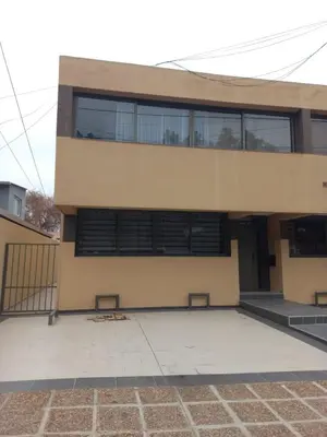 a building with two benches in front of it at Departamentos Económicos Medrano in Villa Carlos Paz
