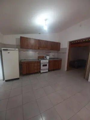 a kitchen with a white refrigerator and wooden cabinets at Departamento Peña in Villa Carlos Paz