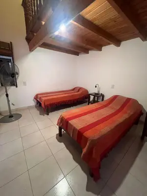 a room with two beds and a fan in it at Departamento Peña in Villa Carlos Paz