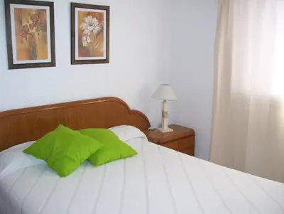 a bed with a green pillow on top of it at Casa Chaco in Villa Carlos Paz