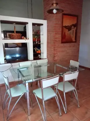 a glass table and chairs in a room at Casa Chaco in Villa Carlos Paz