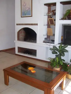 a living room with a fireplace and a coffee table at Casa Chaco in Villa Carlos Paz