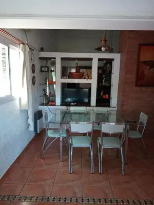 a dining room with a glass table and chairs at Casa Chaco in Villa Carlos Paz