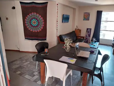 a living room with a table with chairs and a rug at Alquilo departamento en Nueva Córdoba in Cordoba
