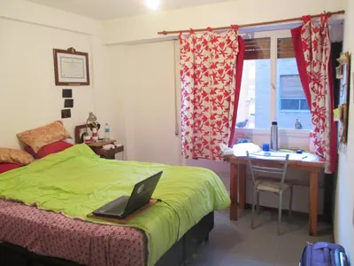 a bedroom with a bed and a desk with a laptop on it at Alquilo departamento en Nueva Córdoba in Cordoba