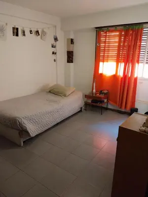 a bedroom with a bed and red curtains at Alquilo departamento en Nueva Córdoba in Cordoba
