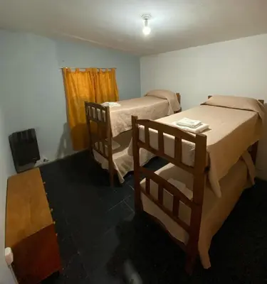 a room with two beds in a room with a window at La Mericia in Villa Carlos Paz