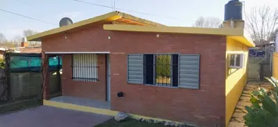 a small red brick house with a window at La Mericia in Villa Carlos Paz