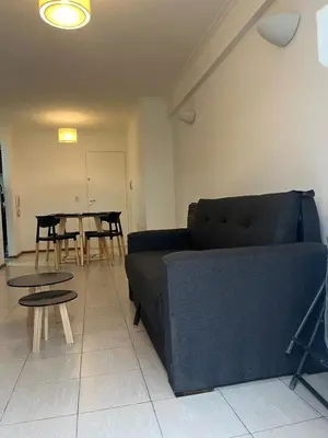 a living room with a blue couch and tables at Raiz - Alquileres Temporarios in Cordoba