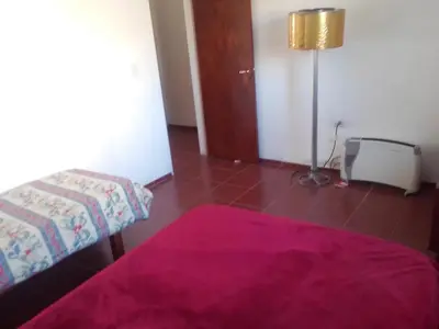 a bedroom with a bed and a floor lamp at Casa de campo in Bialet Massé