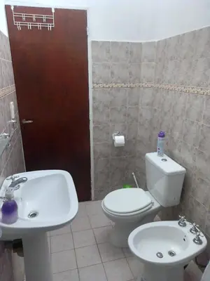 a bathroom with a white toilet and a sink at Casa de campo in Bialet Massé